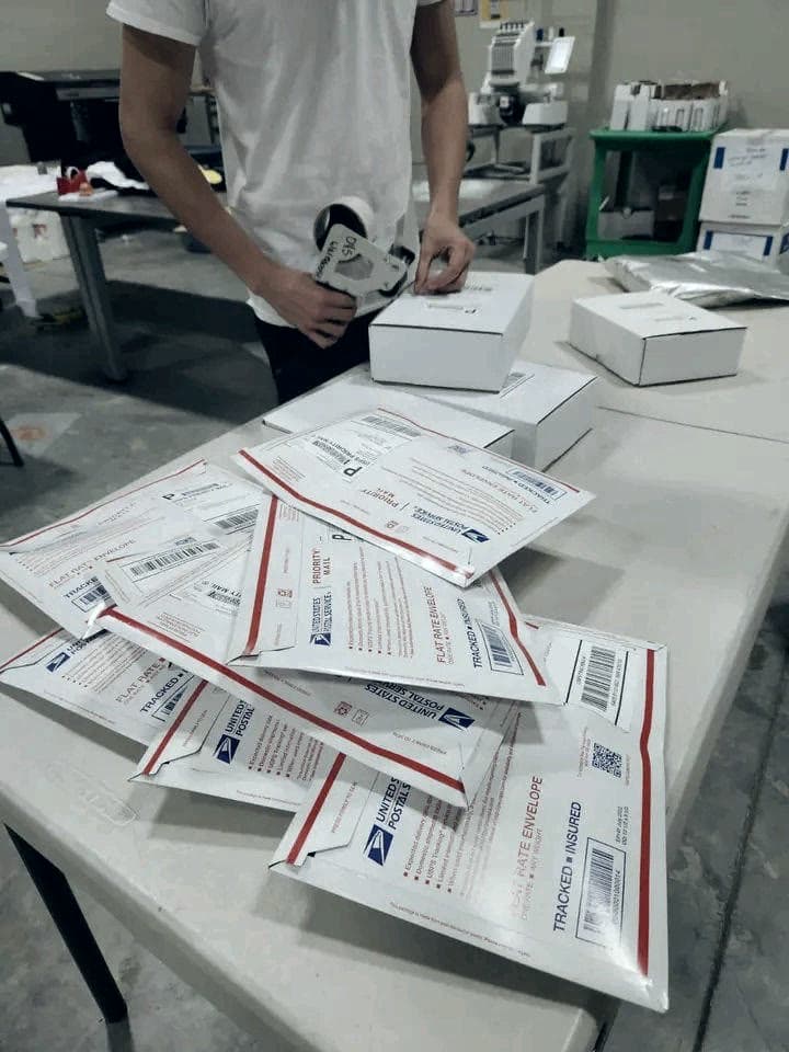 A team member packing and taping parcels at a sorting table